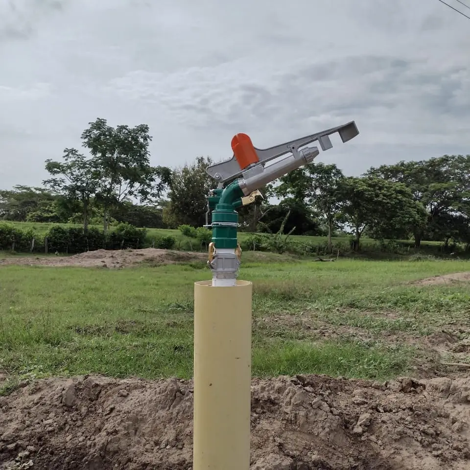 Aspersores regando una pastura verde en una finca ganadera de la Costa Caribe en plena temporada seca